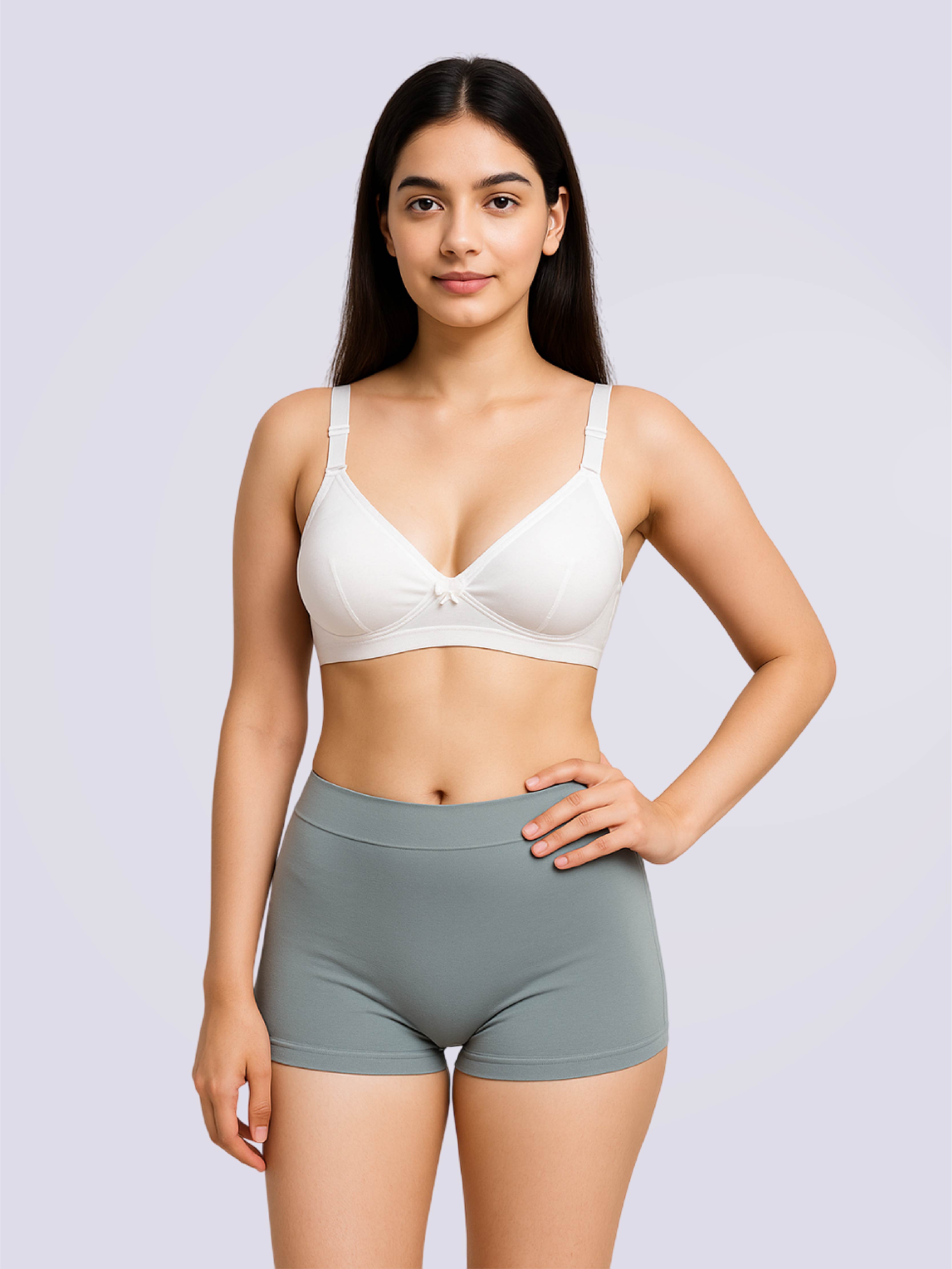 Woman wearing a white bra and gray shorts on a light gray background